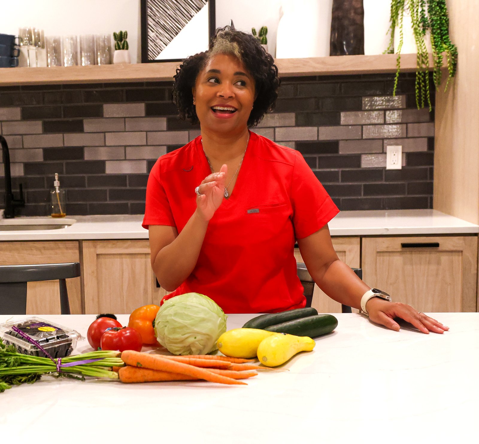 KaTrina Samuels-Garrison talking through a spread of fresh vegetables