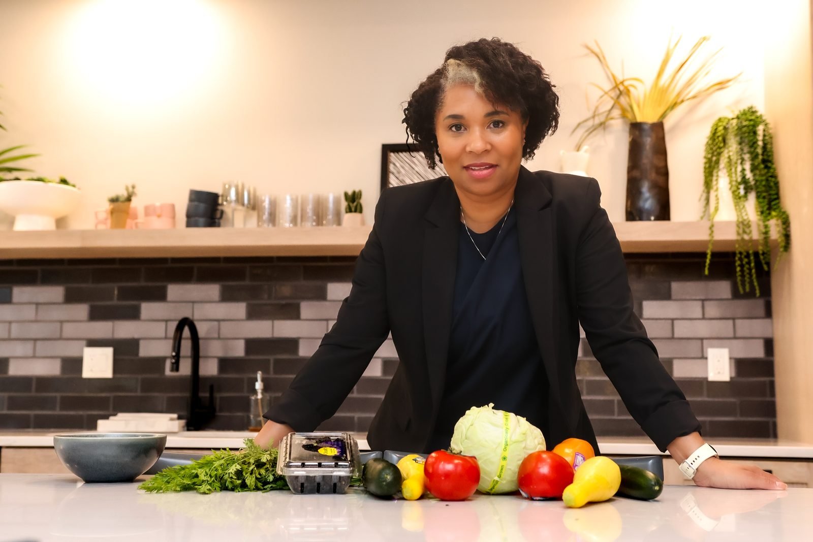 KaTrina Samuels-Garrison standing at a kitchen counter with fresh vegetables
